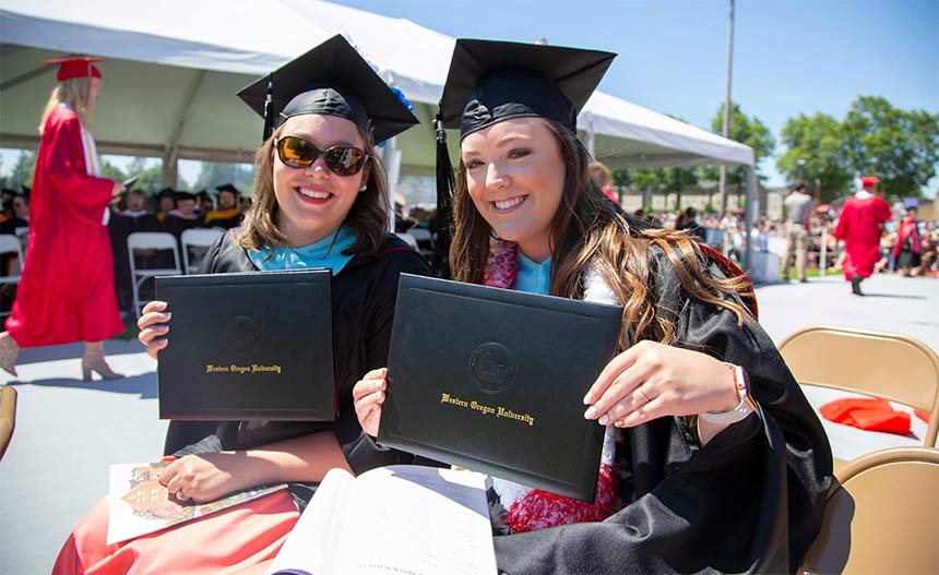 WOU grads holding up their diplomas